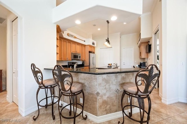 kitchen featuring appliances with stainless steel finishes, pendant lighting, a kitchen breakfast bar, ornamental molding, and kitchen peninsula