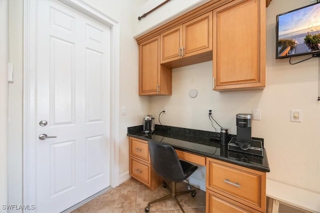 office area with built in desk and light tile patterned floors