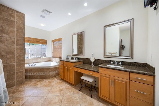 bathroom featuring vanity, tiled tub, and tile patterned floors