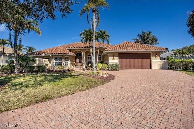 mediterranean / spanish-style home with a garage and a front yard