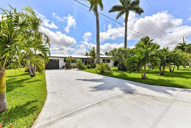 ranch-style house with a garage and a front lawn