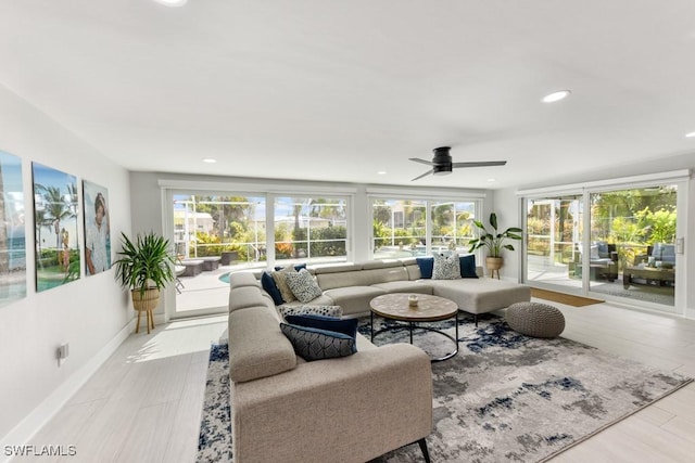 living room with plenty of natural light, ceiling fan, and light hardwood / wood-style floors