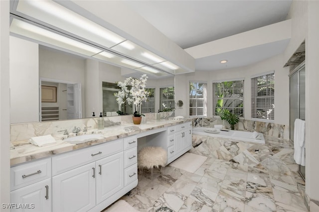 bathroom featuring tiled bath and vanity