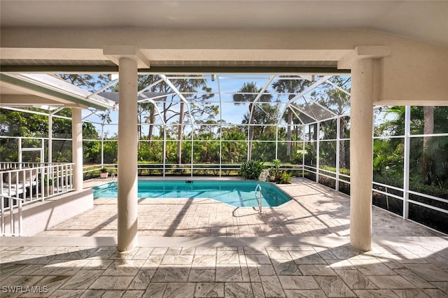 view of pool with glass enclosure and a patio