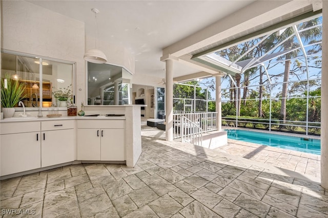 view of pool with sink, a patio, and glass enclosure