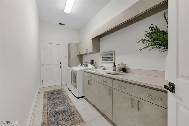 laundry room featuring sink, cabinets, light tile patterned floors, and washing machine and clothes dryer