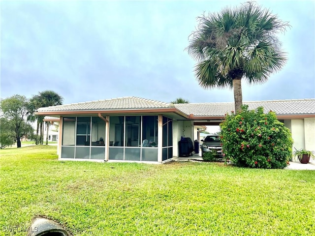 back of house featuring a yard and a sunroom