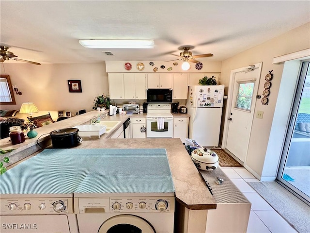 kitchen featuring kitchen peninsula, white cabinets, washer and dryer, light tile patterned flooring, and black appliances