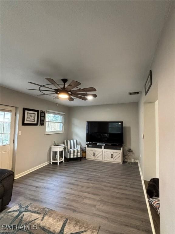 living room with ceiling fan, a wealth of natural light, and dark hardwood / wood-style floors