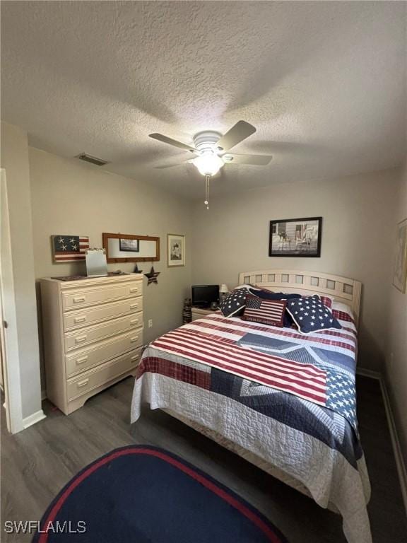 bedroom featuring a textured ceiling, dark hardwood / wood-style floors, and ceiling fan