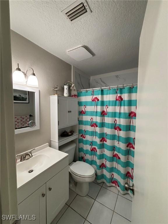 bathroom featuring vanity, toilet, a textured ceiling, and a shower with shower curtain