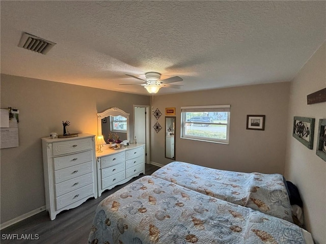 bedroom featuring ceiling fan, a textured ceiling, and dark hardwood / wood-style flooring