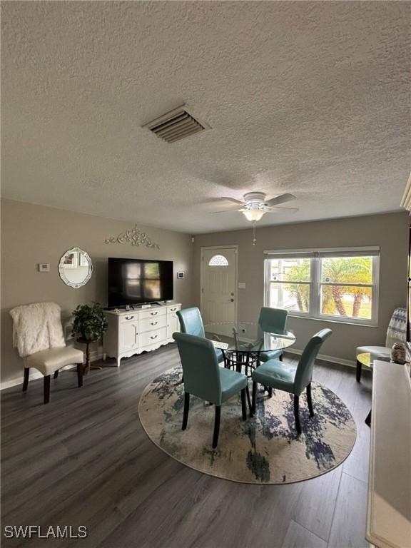 dining room featuring ceiling fan, hardwood / wood-style floors, and a textured ceiling