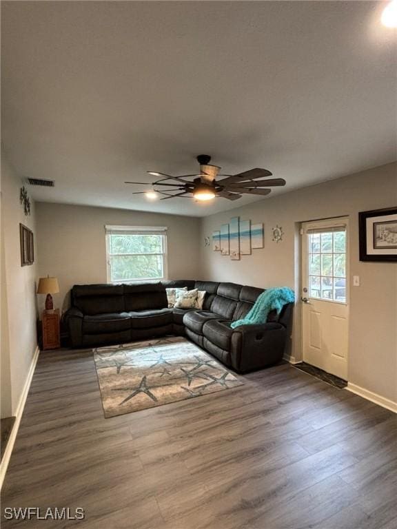 living room featuring ceiling fan and dark wood-type flooring