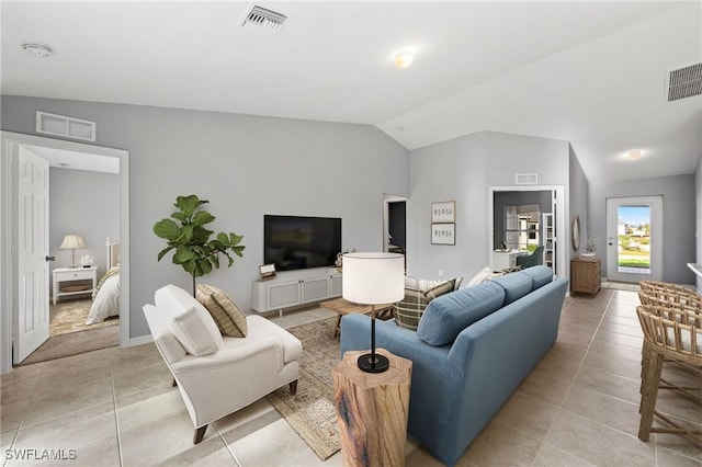 living room featuring vaulted ceiling and light tile patterned floors