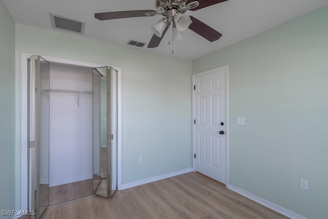 unfurnished bedroom featuring ceiling fan, light hardwood / wood-style floors, and a closet