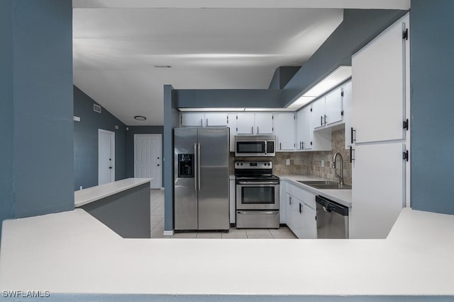 kitchen with white cabinetry, sink, decorative backsplash, and stainless steel appliances