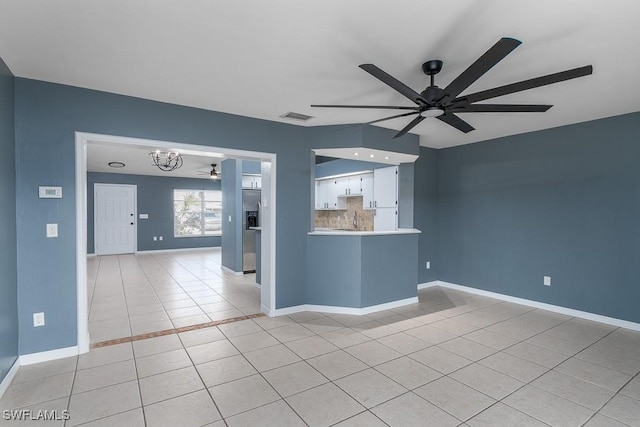 tiled spare room featuring sink and ceiling fan with notable chandelier