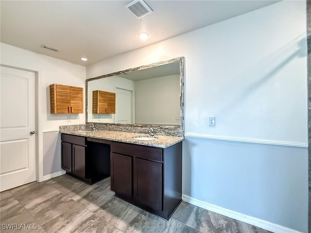 bathroom featuring double vanity, a sink, and visible vents