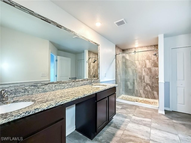 bathroom with tiled shower and vanity