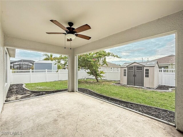 view of patio with ceiling fan and a storage shed