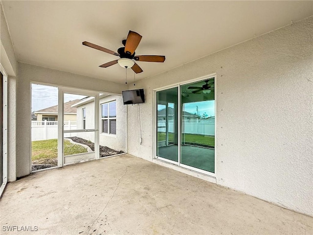 unfurnished sunroom with ceiling fan