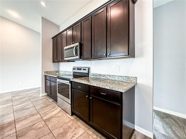 kitchen with appliances with stainless steel finishes, light stone counters, and dark brown cabinetry