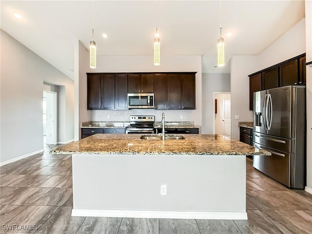 kitchen with an island with sink, appliances with stainless steel finishes, sink, and decorative light fixtures