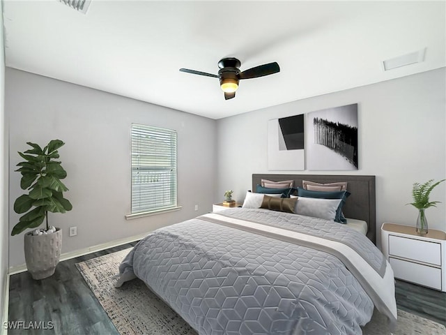 bedroom with ceiling fan, wood finished floors, visible vents, and baseboards