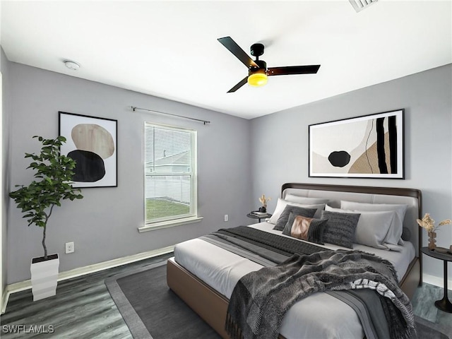 bedroom with ceiling fan, baseboards, and wood finished floors