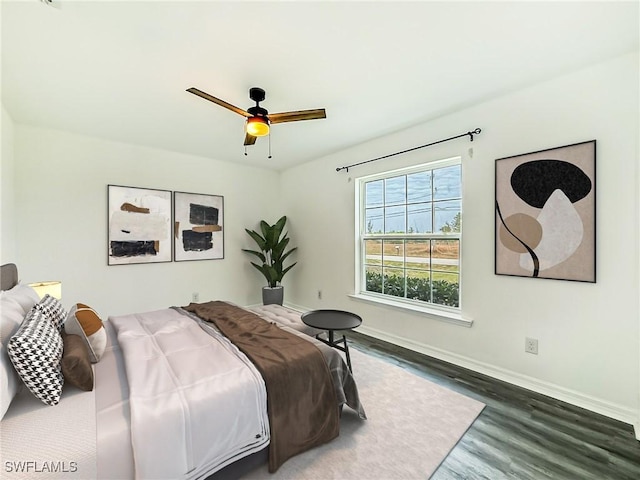 bedroom featuring wood finished floors, a ceiling fan, and baseboards