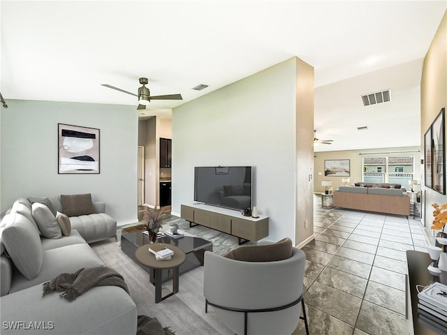 tiled living room featuring ceiling fan, visible vents, and baseboards