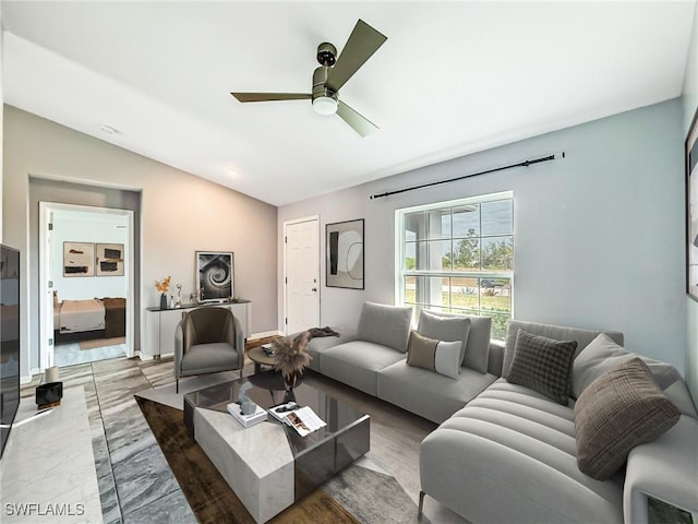 living area with marble finish floor, ceiling fan, baseboards, and vaulted ceiling