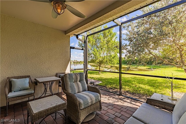 sunroom / solarium with ceiling fan and a water view