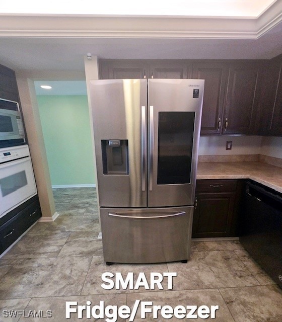 kitchen featuring white appliances, light countertops, and dark brown cabinetry