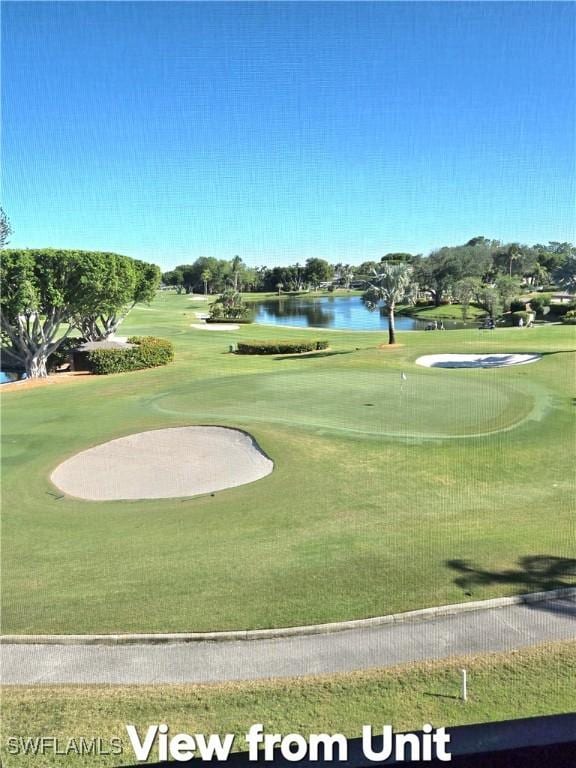 view of home's community featuring view of golf course, a water view, and a lawn