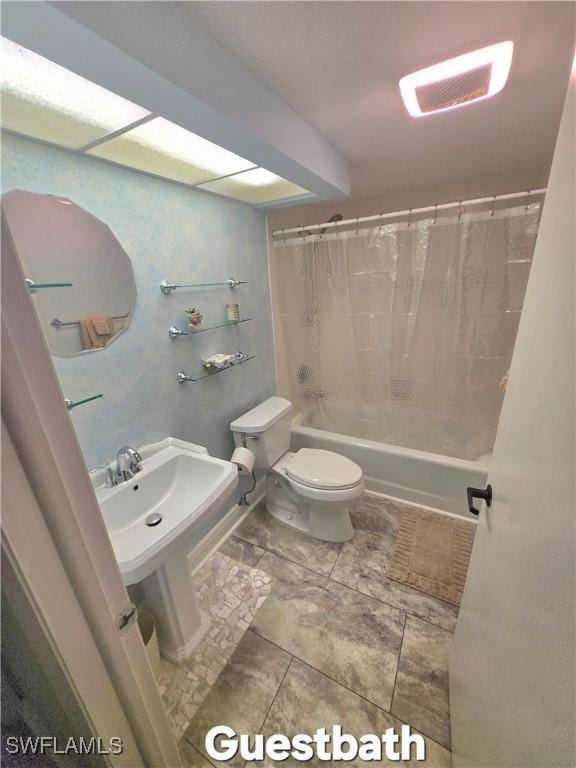 bathroom featuring shower / bath combo and toilet