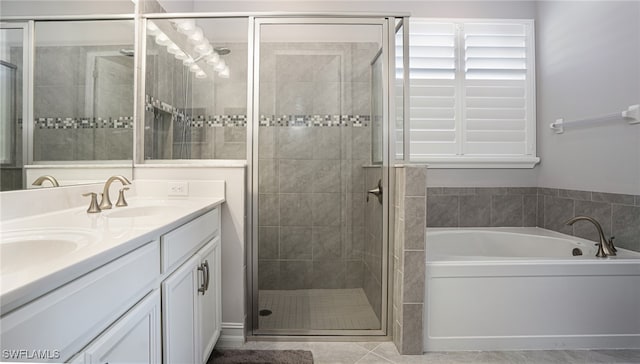 bathroom with tile patterned floors, vanity, and shower with separate bathtub