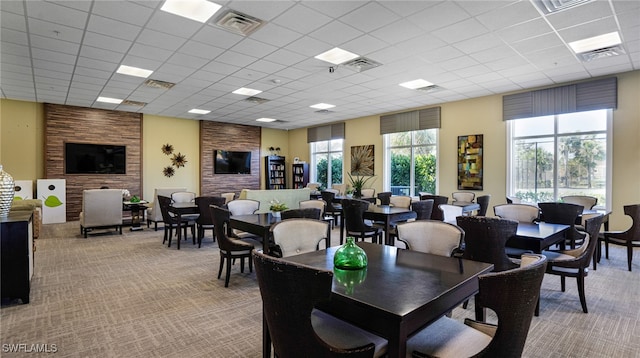 carpeted dining room with a paneled ceiling