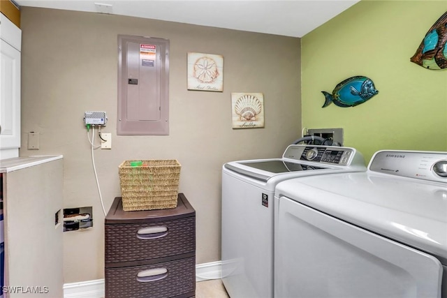 laundry area with laundry area, electric panel, washing machine and dryer, and baseboards