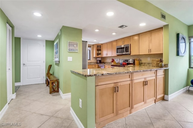 kitchen featuring a peninsula, light stone countertops, visible vents, and appliances with stainless steel finishes