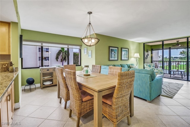 dining area featuring floor to ceiling windows, light tile patterned flooring, and baseboards