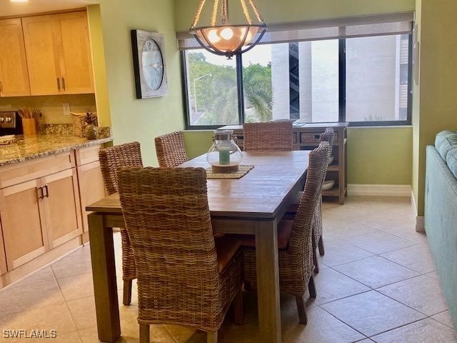 dining area featuring light tile patterned floors and baseboards