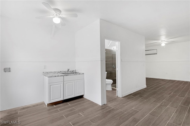 bathroom featuring ceiling fan, a wall mounted air conditioner, toilet, walk in shower, and vanity