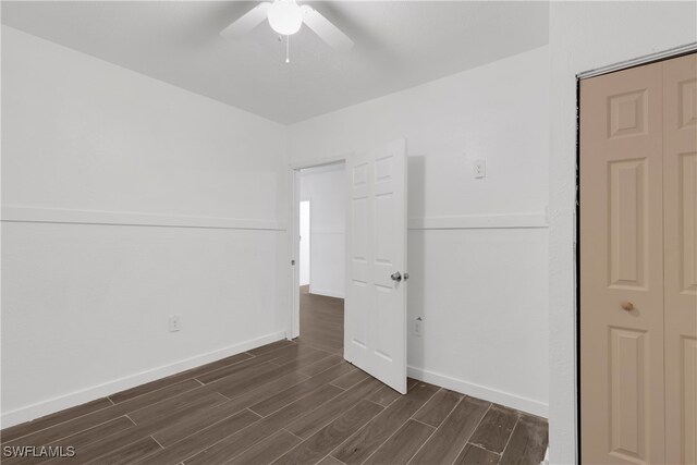 unfurnished bedroom featuring dark wood-type flooring and ceiling fan