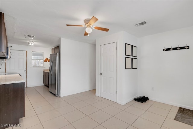 tiled spare room with ceiling fan