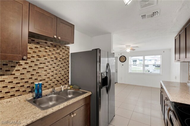 kitchen featuring appliances with stainless steel finishes, tasteful backsplash, sink, light tile patterned floors, and ceiling fan