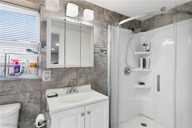 bathroom featuring toilet, a textured ceiling, an enclosed shower, tile walls, and vanity