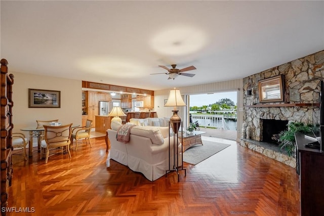 living room with parquet flooring, ceiling fan, and a fireplace