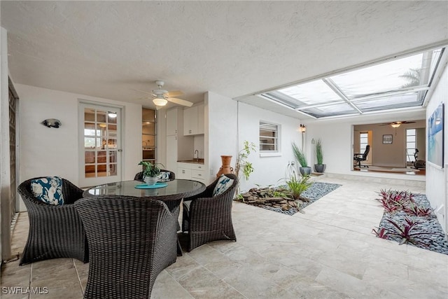 interior space featuring ceiling fan, sink, and a textured ceiling